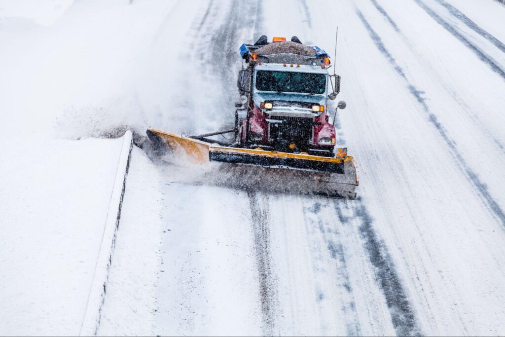 Snowplow removing snow for safer winter road conditions during a snowstorm.