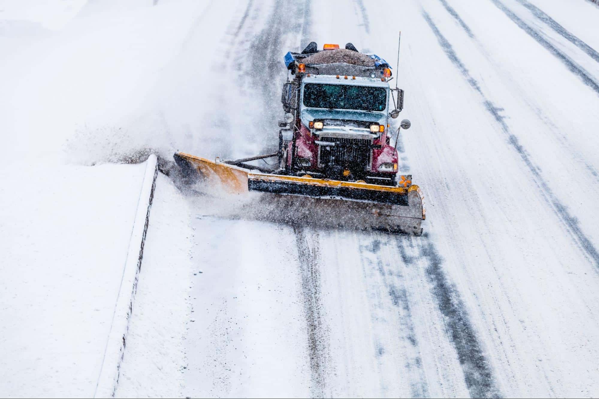 Snowplow removing snow for safer winter road conditions during a snowstorm.