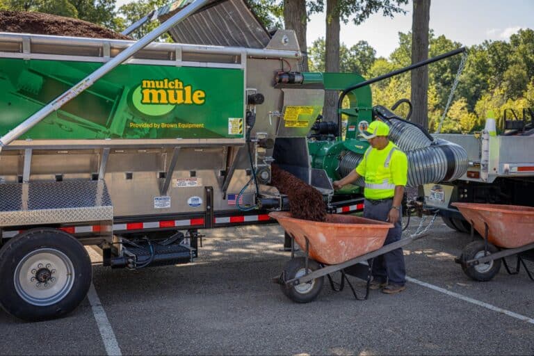 Efficiently processing mulch for gardens with the Mulch Mule machine and operator.