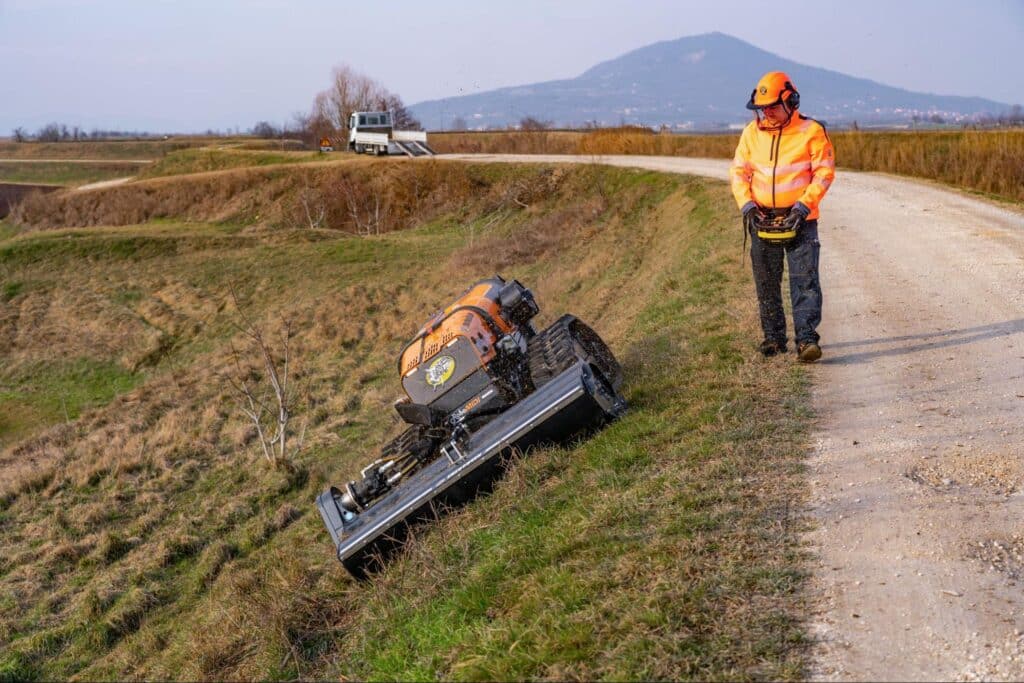 Operator assessing mower performance on a rural dirt road.