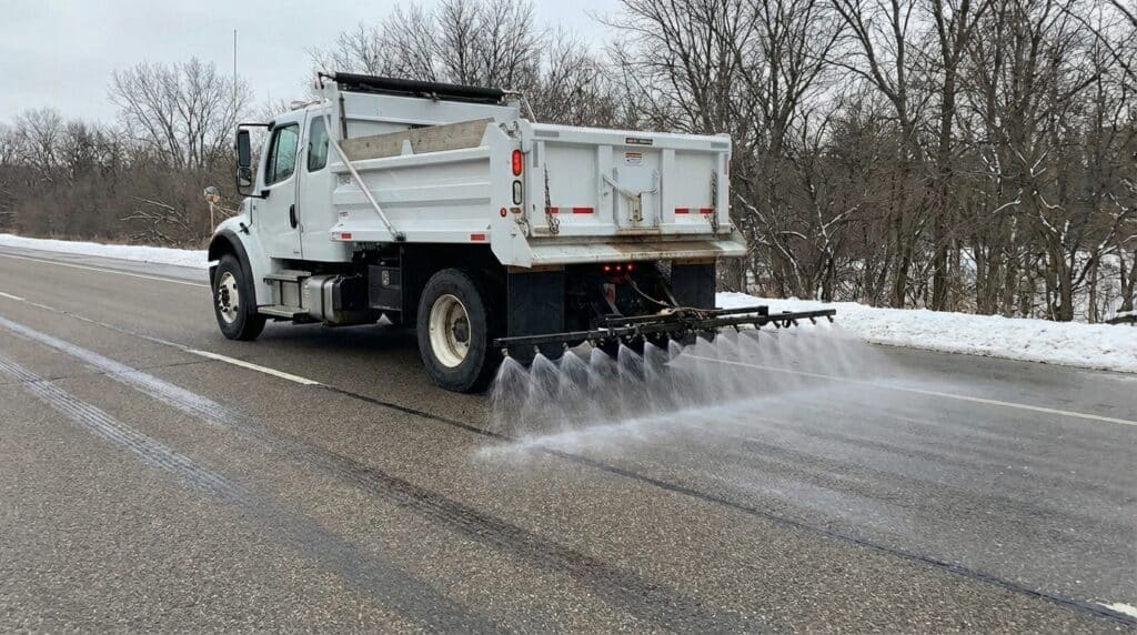Brine application truck treating icy roads for safe winter travel.