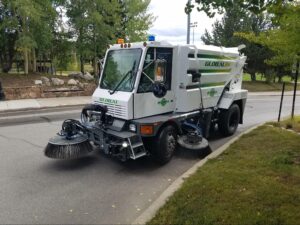 Urban street sweeper improving fall cleanliness on city roads.