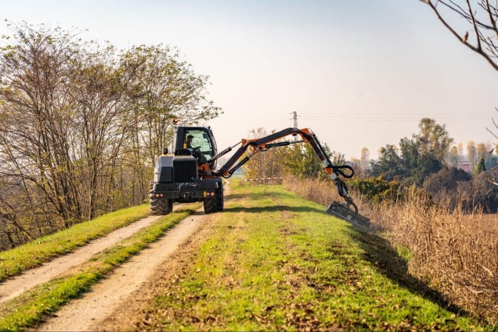 Energreen technology efficiently trims vegetation along a grassy roadside path.