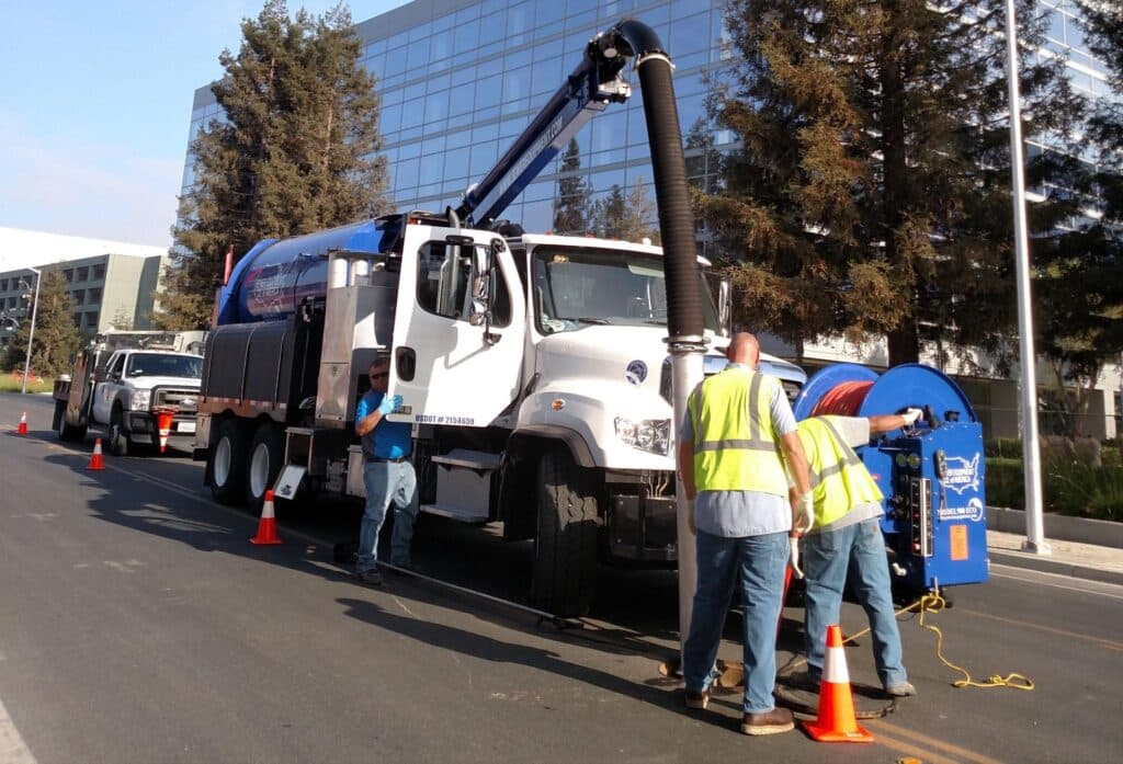 Utility crew using a truck for street maintenance and cleanup activities.