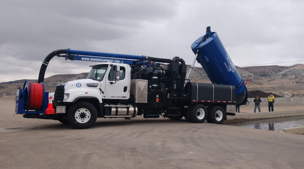 Vacuum truck efficiently removing waste in an outdoor environment.
