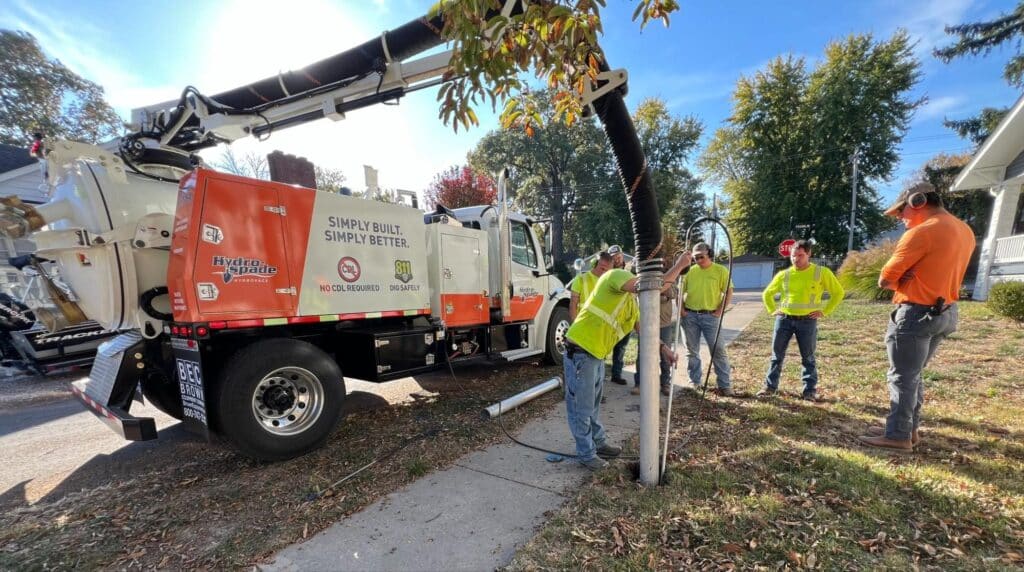 Hydrovac team conducting street maintenance in autumn on a residential street.