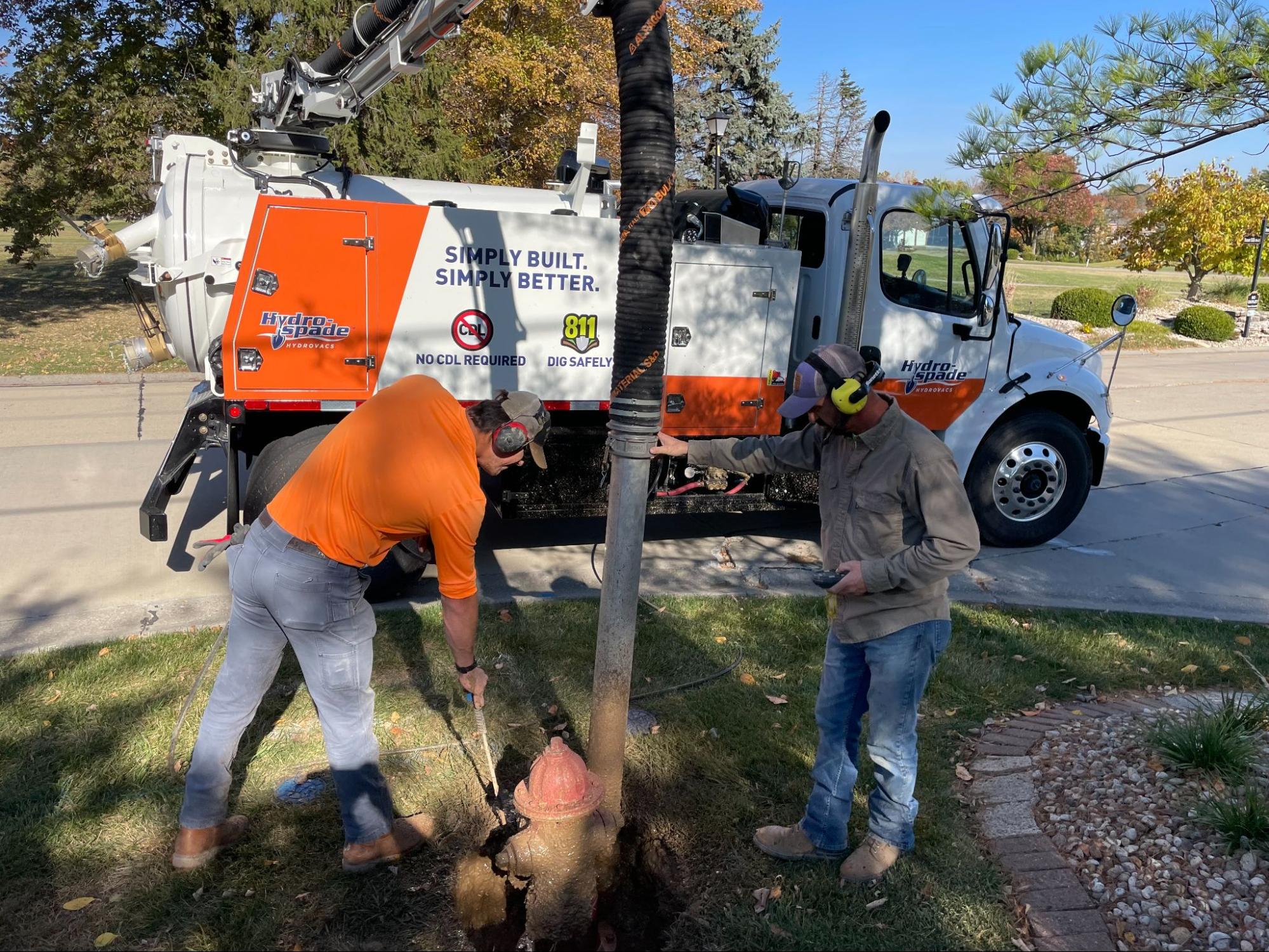 Hydrovac team conducts essential repairs in a residential area with advanced equipment.
