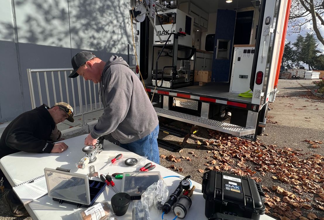 Technicians setting up IBAK equipment outdoors for inspection and image capture.