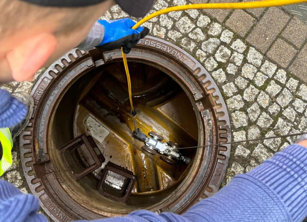 Technician inspecting sewer system using advanced IBAK camera technology.