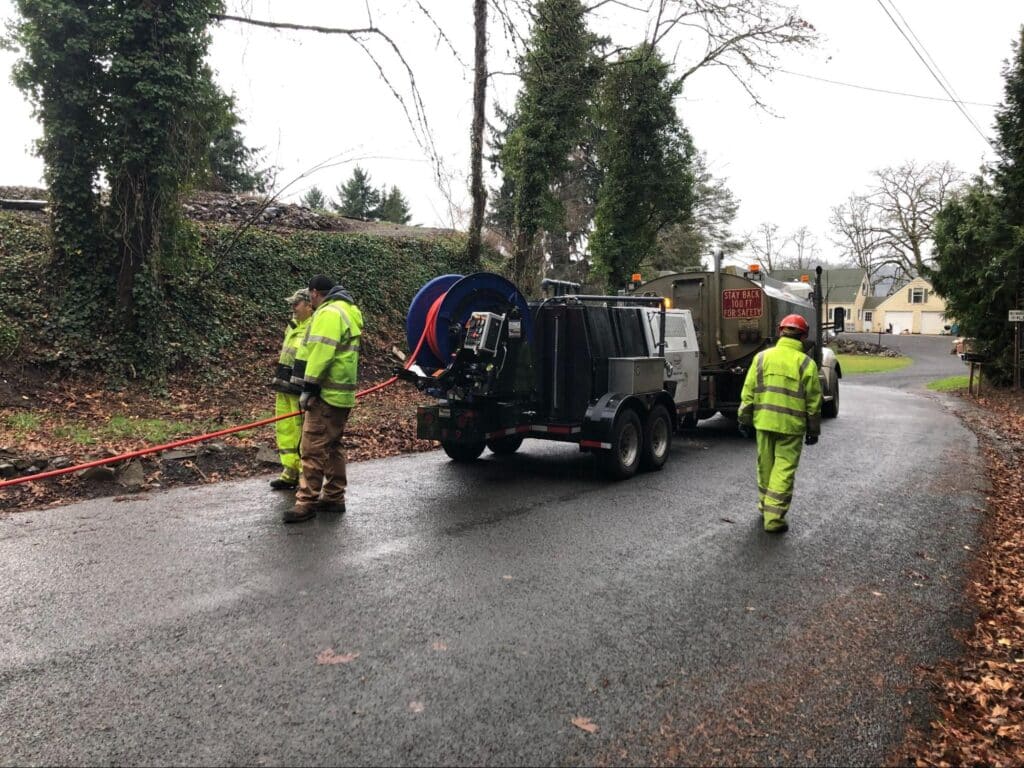 Utility workers upgrading residential road systems using specialized equipment.