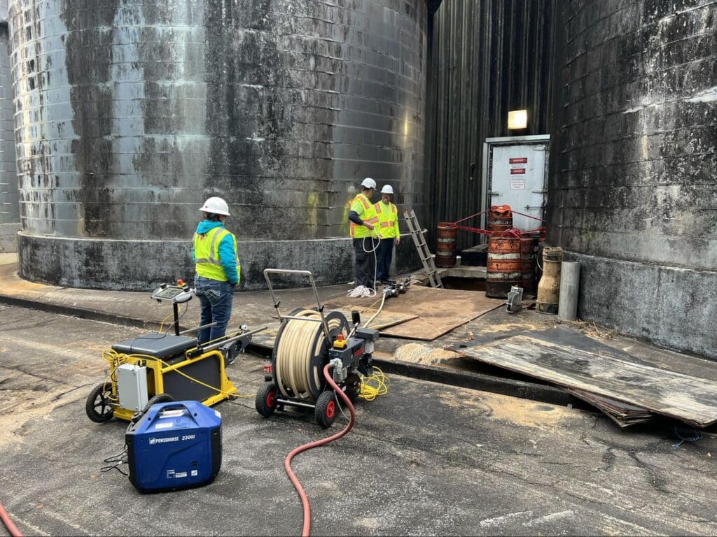 Workers in safety gear conducting maintenance at an industrial facility.